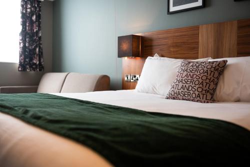 a bedroom with a large bed with a pillow at The Oatlands Chaser by Innkeeper's Collection in Weybridge