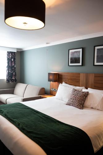 a bedroom with a large bed and a couch at The Oatlands Chaser by Innkeeper's Collection in Weybridge