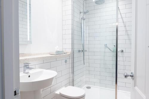 a bathroom with a toilet and a sink and a shower at The Oatlands Chaser by Innkeeper's Collection in Weybridge