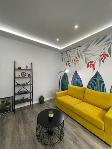 een woonkamer met een gele bank en een tafel bij Lovely new apartment near Tirana's artificial Lake in Tirana