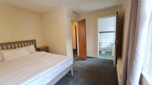 a bedroom with a bed and a bathroom with a toilet at Grace Apartments - Living Rock in Ashford