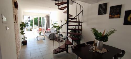 a living room with a spiral staircase and a table at Mediterranean Seaside Authentic Beach House in Polis Chrysochous