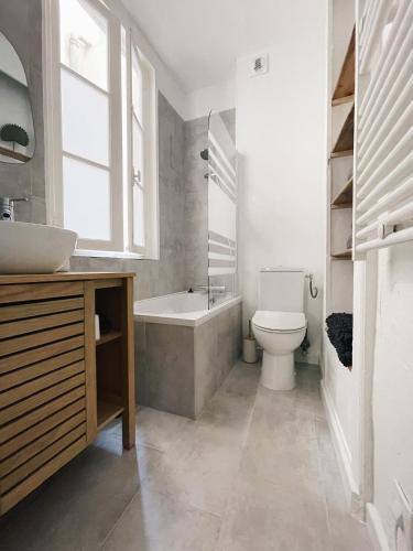 une salle de bain avec une baignoire, des toilettes et un lavabo dans l'établissement Le Patio de La Rochelle, à La Rochelle