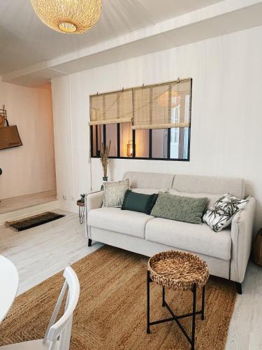 un salon avec un canapé et une table dans l'établissement Le Patio de La Rochelle, à La Rochelle