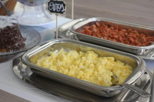 two trays of food on a table with food at Pousada Ilha das Conchas in Guarujá