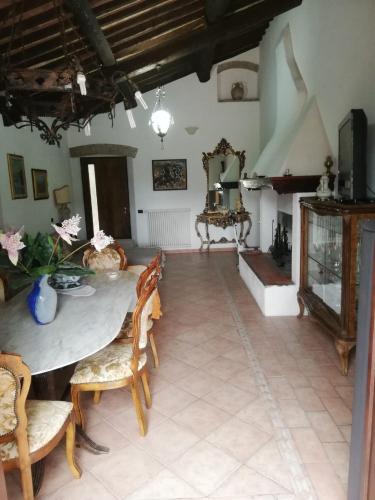 a living room with a table and chairs and a fireplace at Confortevole locale in Rosignano Marittimo