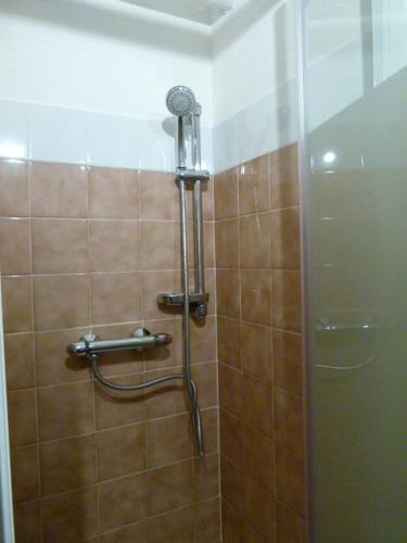 une douche avec pommeau de douche dans une salle de bain dans l'établissement Appartement EPICEA Residence Front de neige, à Montferrier