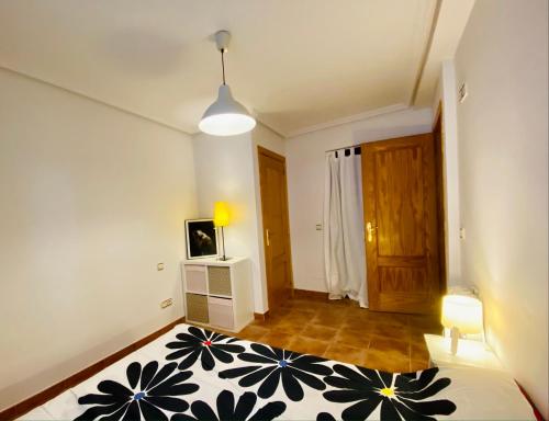 a room with a bed and a television in it at CÓMODO APARTAMENTO RURAL in Torrelaguna