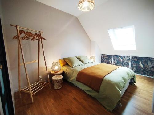 1 dormitorio con 1 cama y suelo de madera en Le Nid - Fougères centre historique, en Fougères