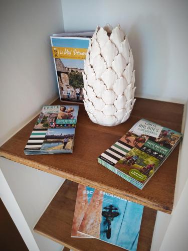 a table with magazines and a vase on top of it at Le Nid - Fougères centre historique in Fougères