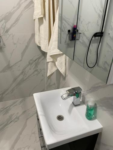 a white bathroom with a sink and a mirror at Prestige Apartment Old Town Zamość in Zamość