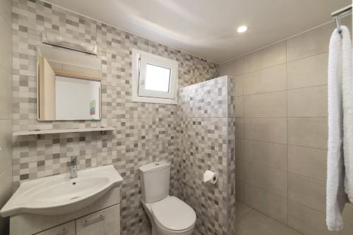 a bathroom with a toilet and a sink at Olive Grove Apartments in Elounda