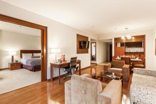 um quarto de hotel com um quarto e uma sala de estar em Tequendama Suites Bogota em Bogotá