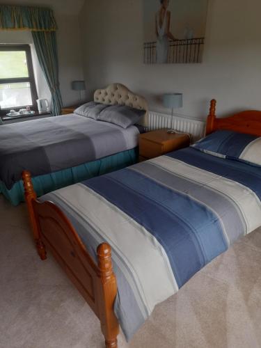 a bedroom with two beds and a window at The Mournes view Farmhouse in Newcastle