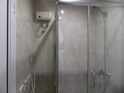 a shower stall with a glass door with a shower at Apartament HOLIDAY in Burgas City