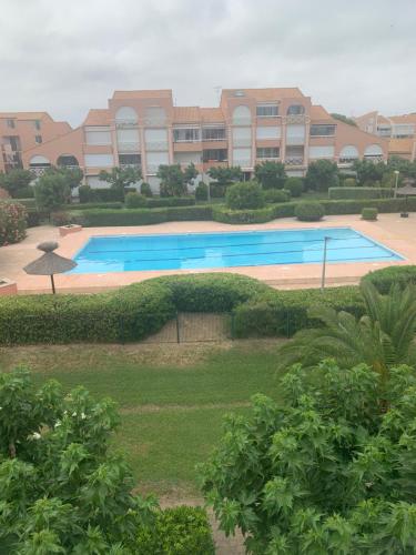 une grande piscine devant un immeuble dans l'établissement APPARTEMENT PALAVAS LES FLOTS AVEC JARDIN et PISCINE, à Palavas-les-Flots