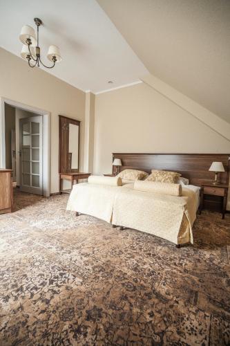 a large bedroom with two beds and a wooden headboard at Dworek nad Rozlewiskiem in Olkusz
