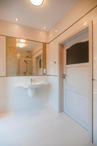 a bathroom with a sink and a large mirror at Dworek nad Rozlewiskiem in Olkusz