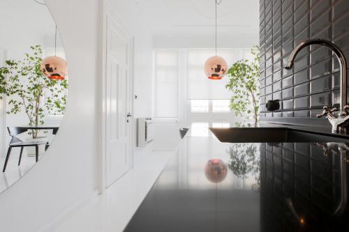 a kitchen with black and white tiles and a sink at Trilogy Black in Thessaloniki