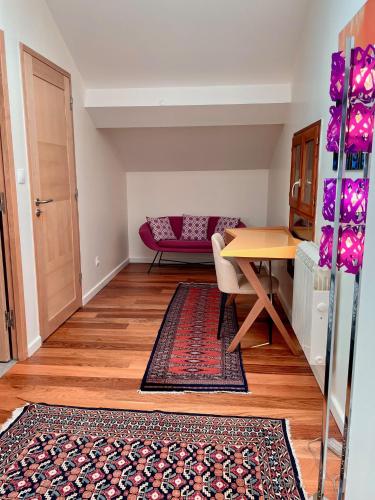 - un salon avec une table et un tapis dans l'établissement Suites & Balnéo chez l'habitant - Vue panoramique sur le Vercors, à Pont-en-Royans