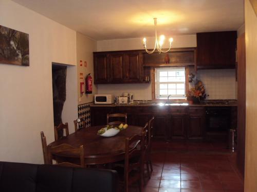 a kitchen with a table and a dining room at Casa do Postigo in Geres