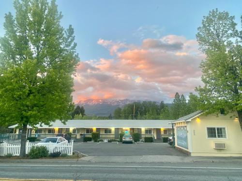 a motel with a parking lot in front of a building at Cold Creek Inn in Mount Shasta