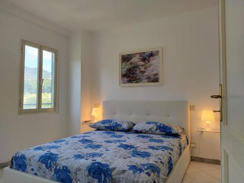 una camera con un letto e un piumone blu e bianco di Mara House a Levanto