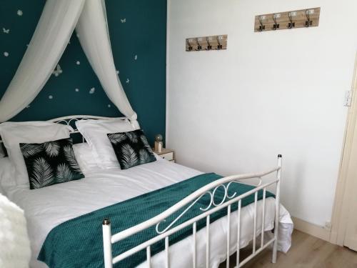 une chambre avec un lit blanc avec un mur vert dans l'établissement DAL PAN BAZZO Sandrine, à Berson