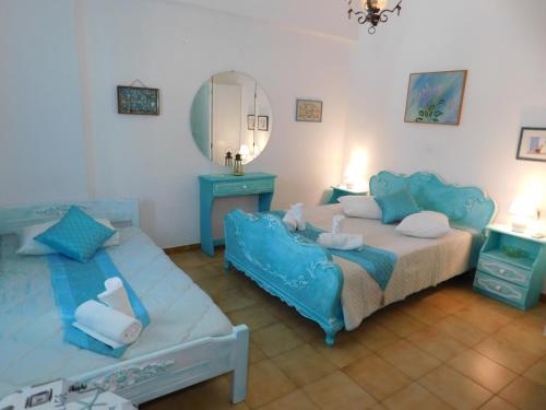 una camera con letto, divano e specchio di Yacht Front Studio - Back Yard - No 7 a Ios Chora