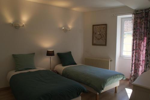 twee bedden in een kamer met een raam bij Escapade bourguignonne in Volnay