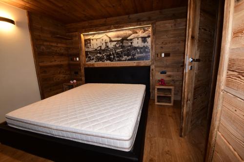 a bedroom with a bed in a wooden room at Chalet Jolie in Livigno