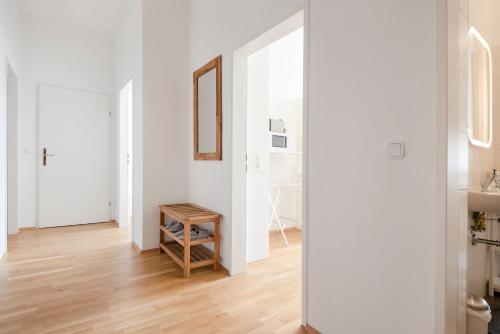 einen Flur mit weißen Wänden und einem Holztisch in der Unterkunft City-Apartments Graz in Graz