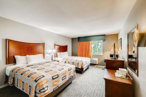 Voodi või voodid majutusasutuse Orangewood Inn and Suites Midtown toas