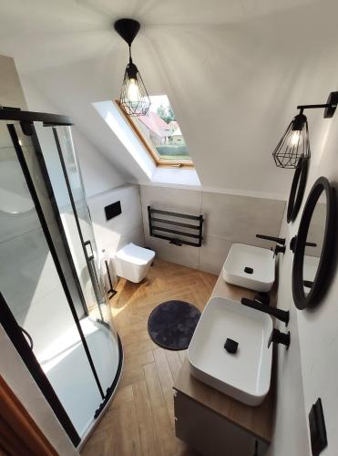an attic bathroom with two sinks and a mirror at Willa Lichaczówka in Bogaczewo