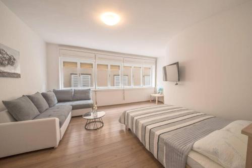 salon z kanapą i łóżkiem w obiekcie Aurora Apartment Zadar w mieście Zadar