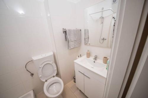a white bathroom with a toilet and a sink at Central View Zadar in Zadar