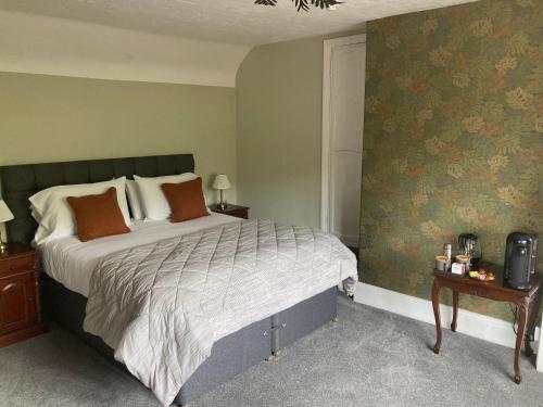 a bedroom with a large bed with orange pillows at Tottington Manor Hotel in Henfield