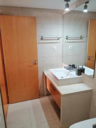 a bathroom with a sink and a mirror at Apartamento Duplex - Cabanas Garden in Tavira