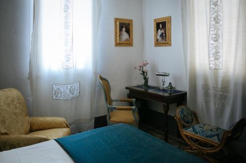 a bedroom with a bed and a table and chairs at Domus Socolatae Residenza d'Epoca Charming B&B - Adults Only in Follonica