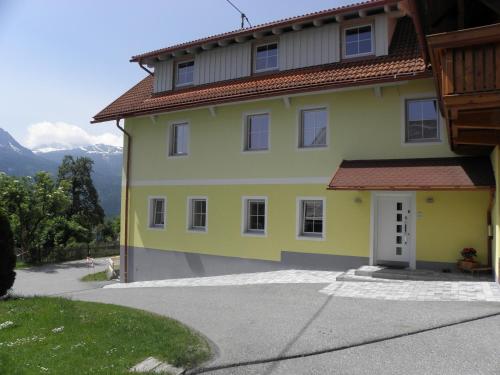 a yellow house with a red roof at Waldner's Ferienwohnung in Hermagor