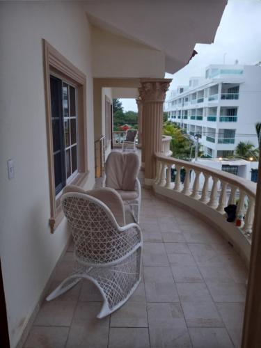 a balcony with two chairs and a railing at Rolando share apart in Punta Cana