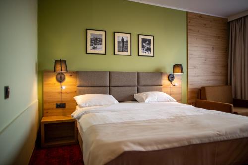 a bedroom with a large white bed with two lamps at Pensiunea La Bella Vista in Poiana Negrii