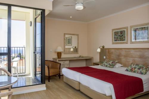 une chambre d'hôtel avec un lit et un balcon dans l'établissement Estúdio vista mar triplo, à Funchal