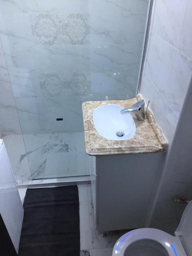 a bathroom with a sink and a shower and a toilet at Ultracentral zona zero apartament in Bacău