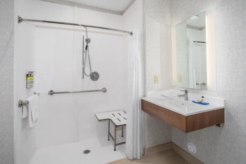 格倫代爾的住宿－Holiday Inn Express & Suites Phoenix Glendale Dist, an IHG Hotel，白色的浴室设有水槽和淋浴。