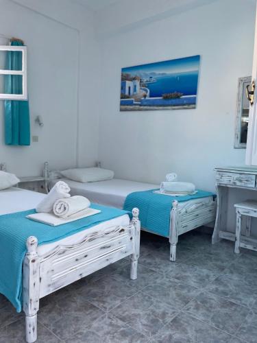 a bedroom with two beds and a piano at Anna Maria Rooms Santorini in Perissa
