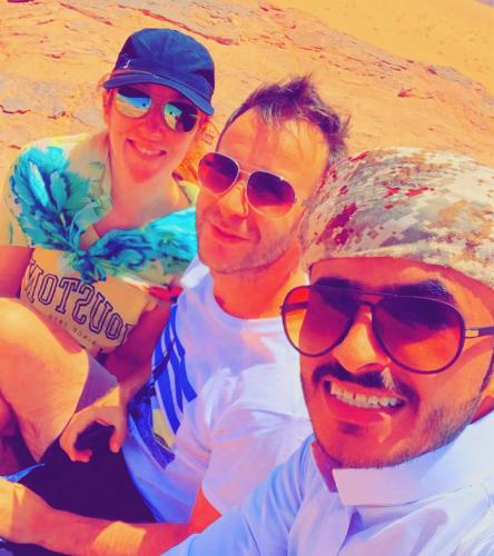 a group of three people posing for a picture on the beach at Sand Star Camp in Wadi Rum