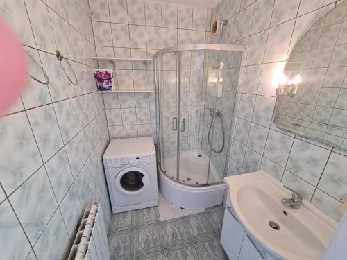 a bathroom with a washing machine next to a sink at Apartament Mragowo in Mrągowo