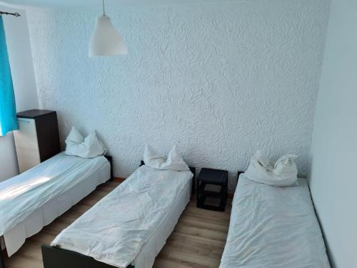 two beds in a room with white walls at Apartament Mragowo in Mrągowo