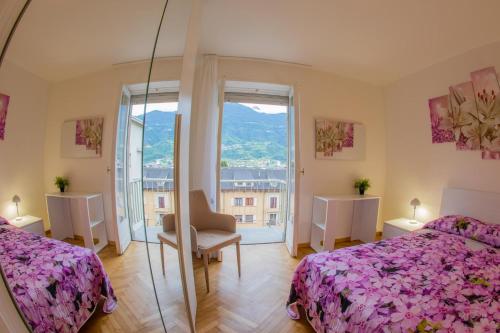 1 dormitorio con 2 camas y espejo en Lorenzo's Apartament en Aosta